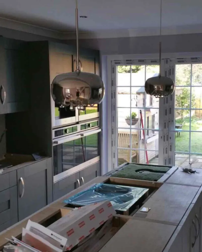 Two chrome pendant lights hung over a kitchen island during a kitchen refit